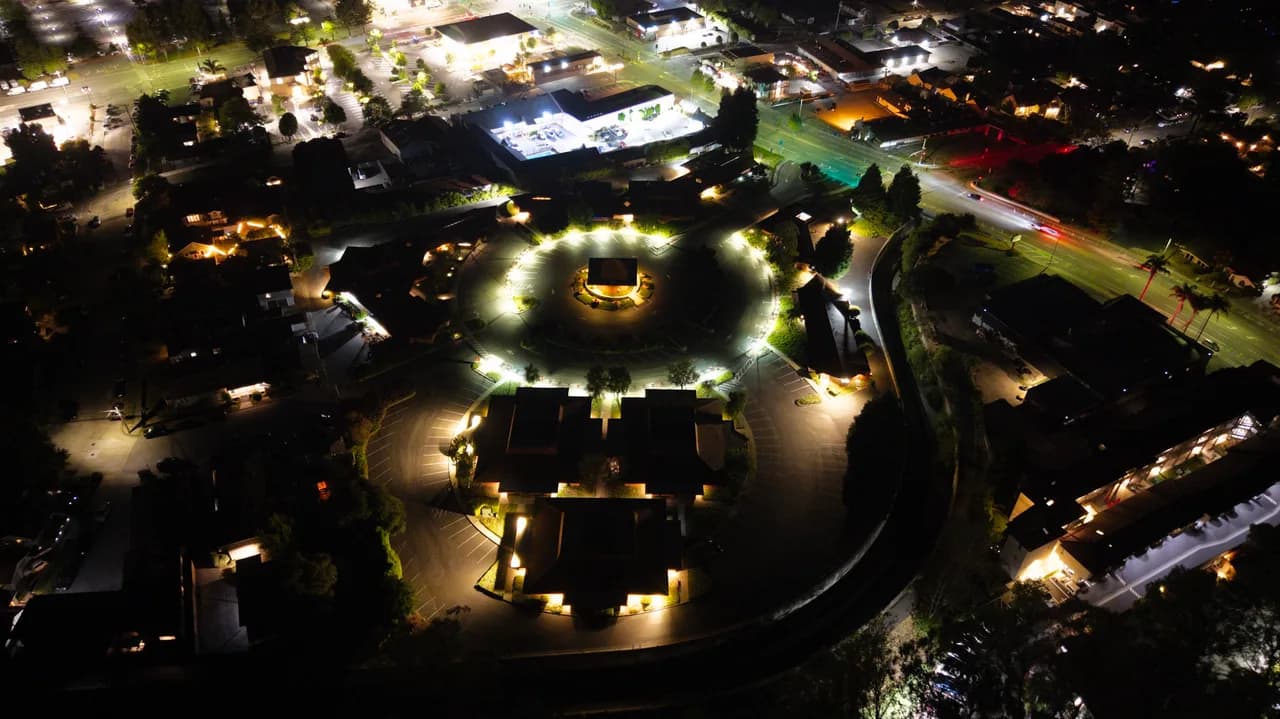 Pools of light outline a circular plaza and its central pavilion, seen from above. After Dark photo 2 of 9.